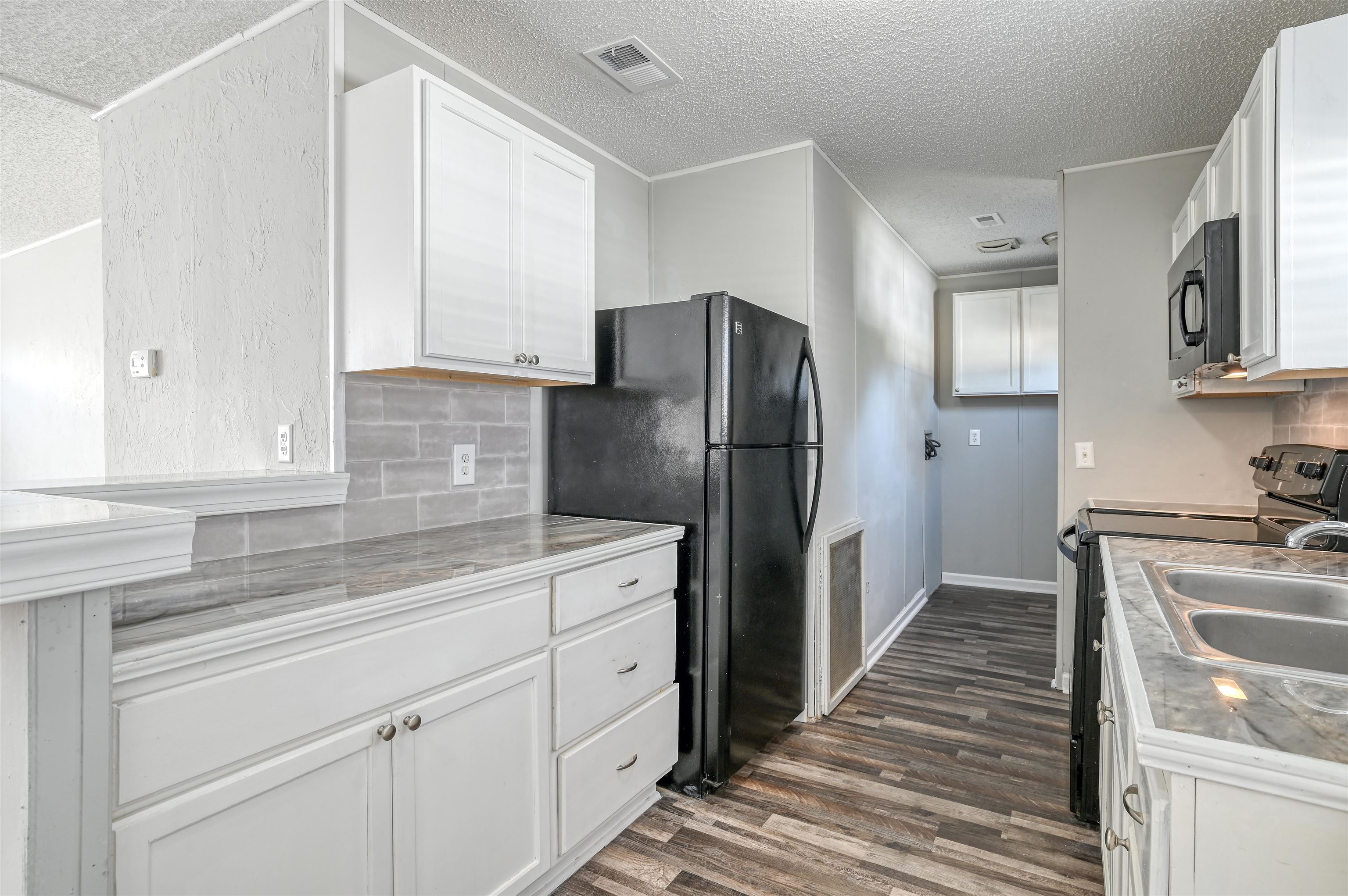 4661 Second Avenue St. Augustine, FL 32095 - Photo 11 of 26 a kitchen with a refrigerator sink and cabinets