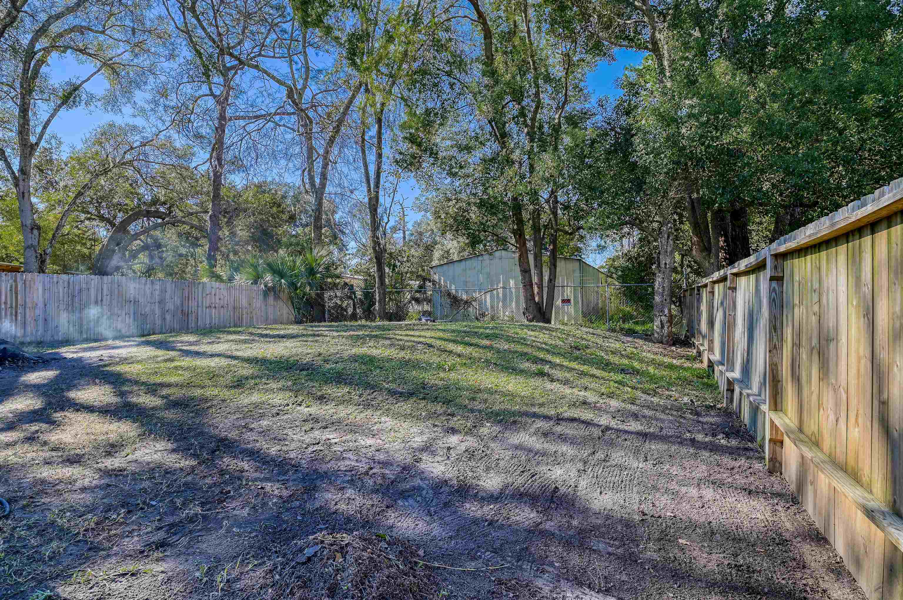 4661 Second Avenue St. Augustine, FL 32095 - Photo 24 of 26 a view of a backyard with large trees and wooden fence