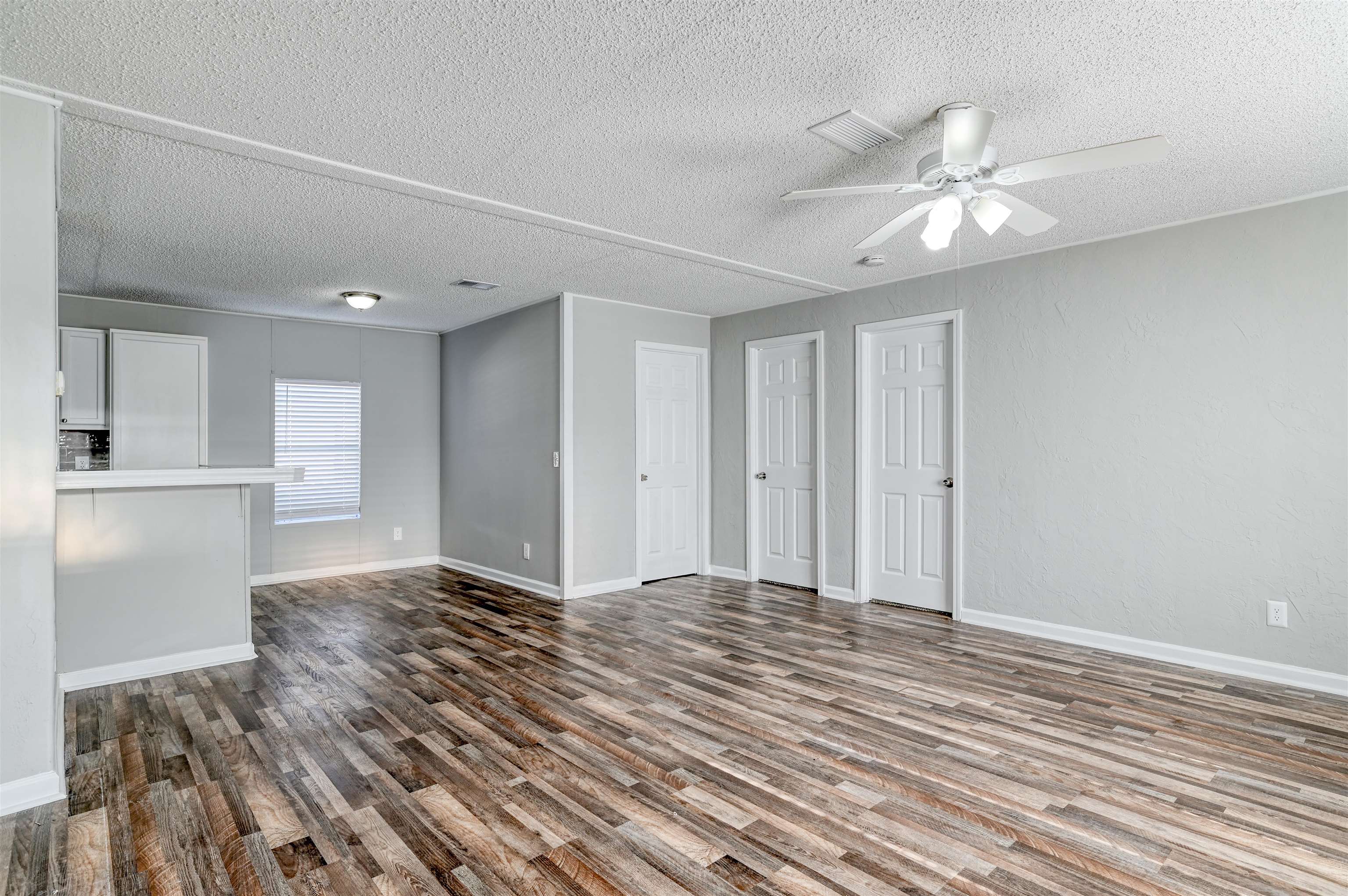 4661 Second Avenue St. Augustine, FL 32095 - Photo 5 of 26 a view of an empty room with wooden floor and a ceiling fan