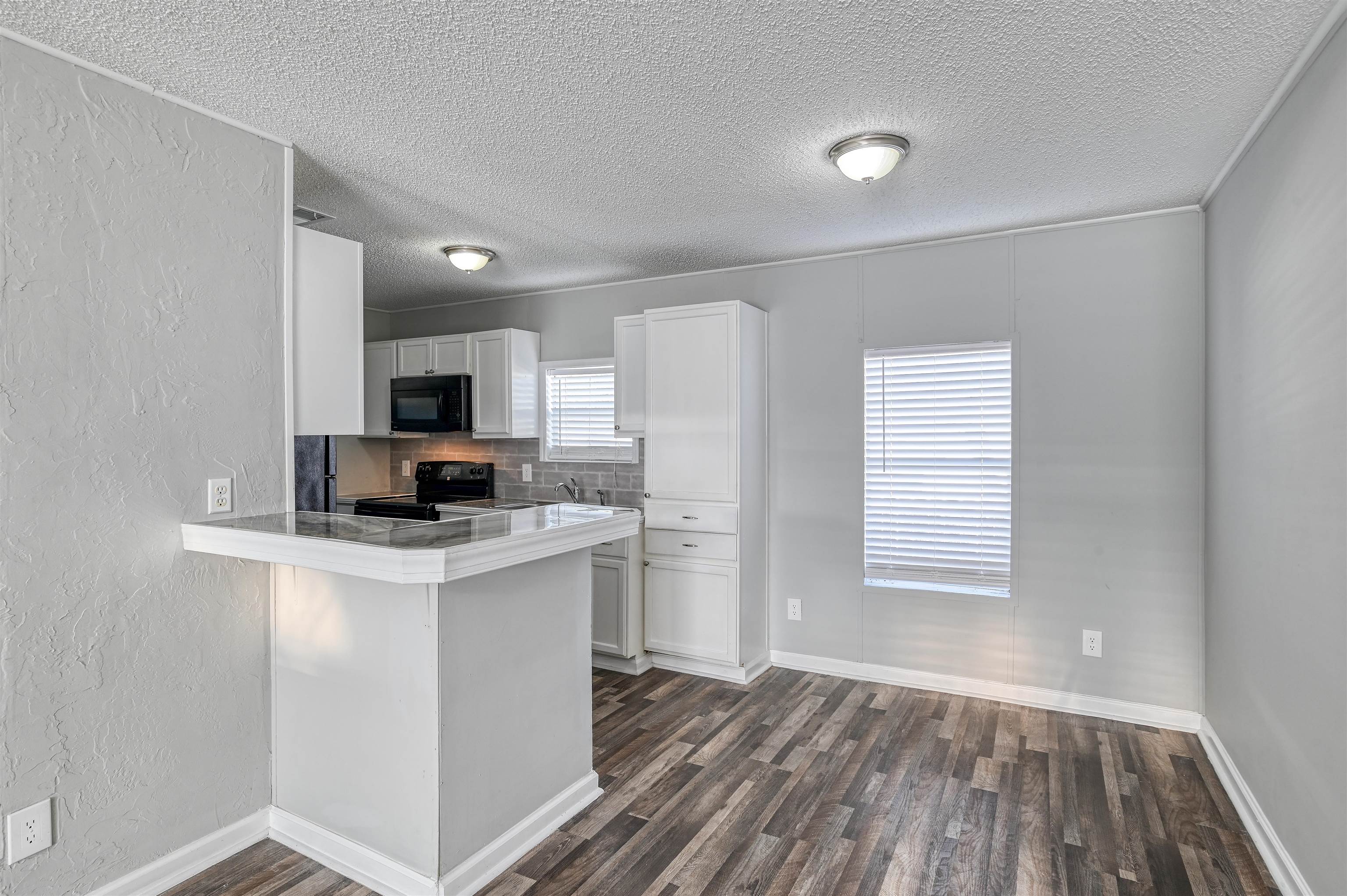4661 Second Avenue St. Augustine, FL 32095 - Photo 9 of 26 a kitchen with kitchen island a sink cabinets and wooden floor
