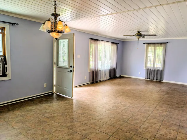 an empty room with windows and chandelier
