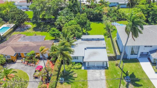 an aerial view of residential house with pool and garden