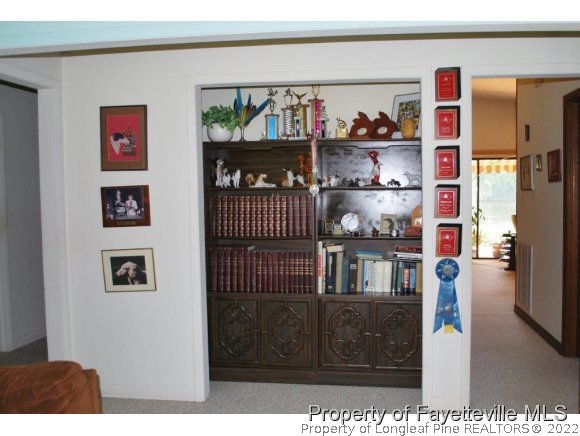 7371 Sherrill Baggett Road Dunn, NC 28334 - Photo 20 of 25 a living room with lots of furniture and a book shelf