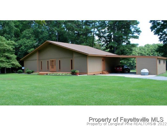 7371 Sherrill Baggett Road Dunn, NC 28334 - Photo 24 of 25 a house with green field in front of it
