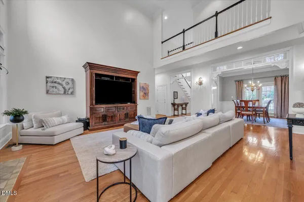 a large kitchen with stainless steel appliances granite countertop a stove a sink dishwasher a refrigerator white cabinets and wooden floor