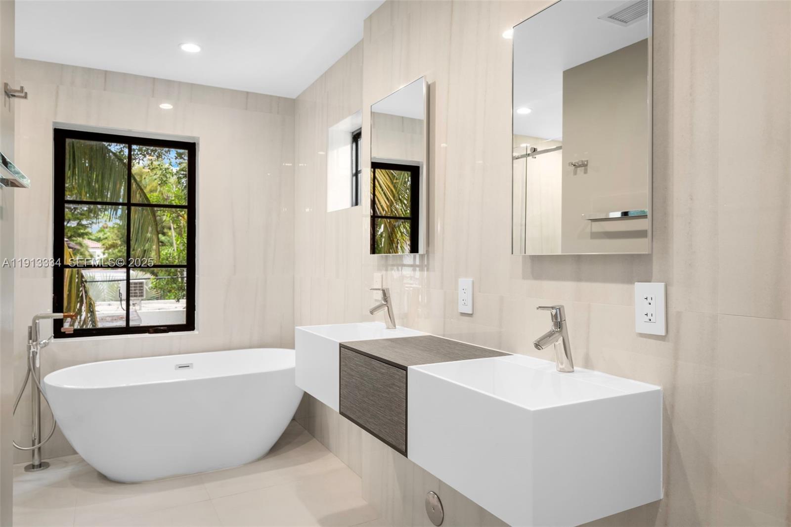 151 Northeast 43rd Street Miami, FL 33137 - Photo 13 of 51 a bathroom with a bathtub a sink and a window