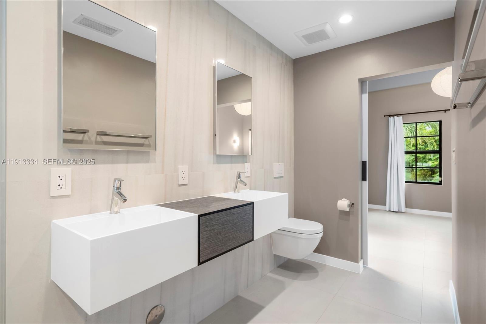 151 Northeast 43rd Street Miami, FL 33137 - Photo 16 of 51 a bathroom with a toilet sink and mirror