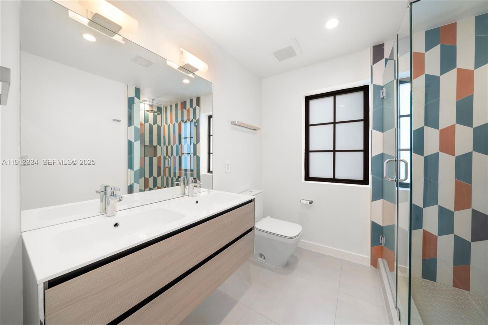 151 Northeast 43rd Street Miami, FL 33137 - Photo 23 of 51 a bathroom with a sink toilet a shower and a mirror