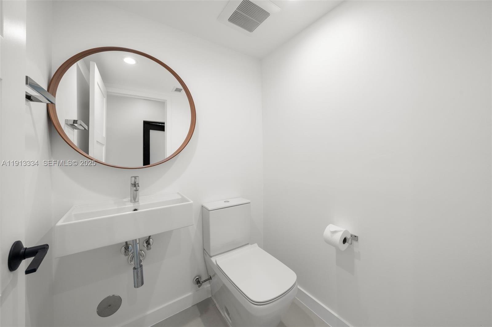 151 Northeast 43rd Street Miami, FL 33137 - Photo 26 of 51 a bathroom with a toilet sink and mirror