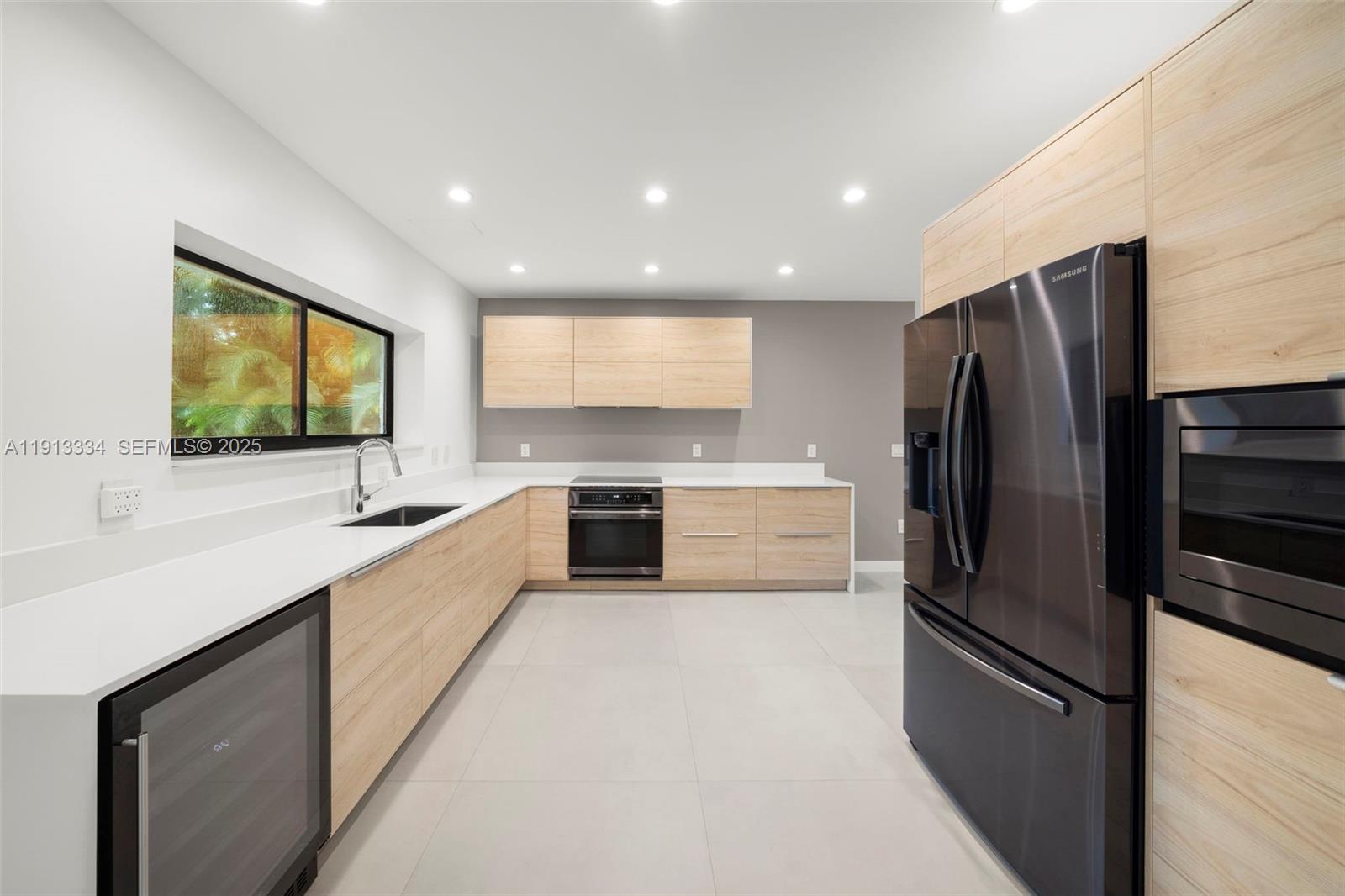 151 Northeast 43rd Street Miami, FL 33137 - Photo 28 of 51 a large kitchen with a large window and stainless steel appliances