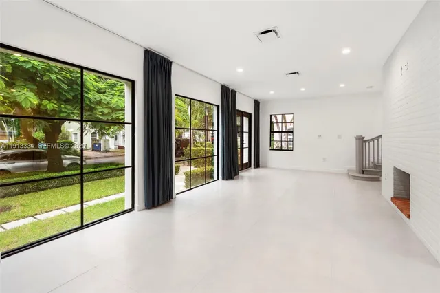 a view of an empty room with a fireplace and a large window