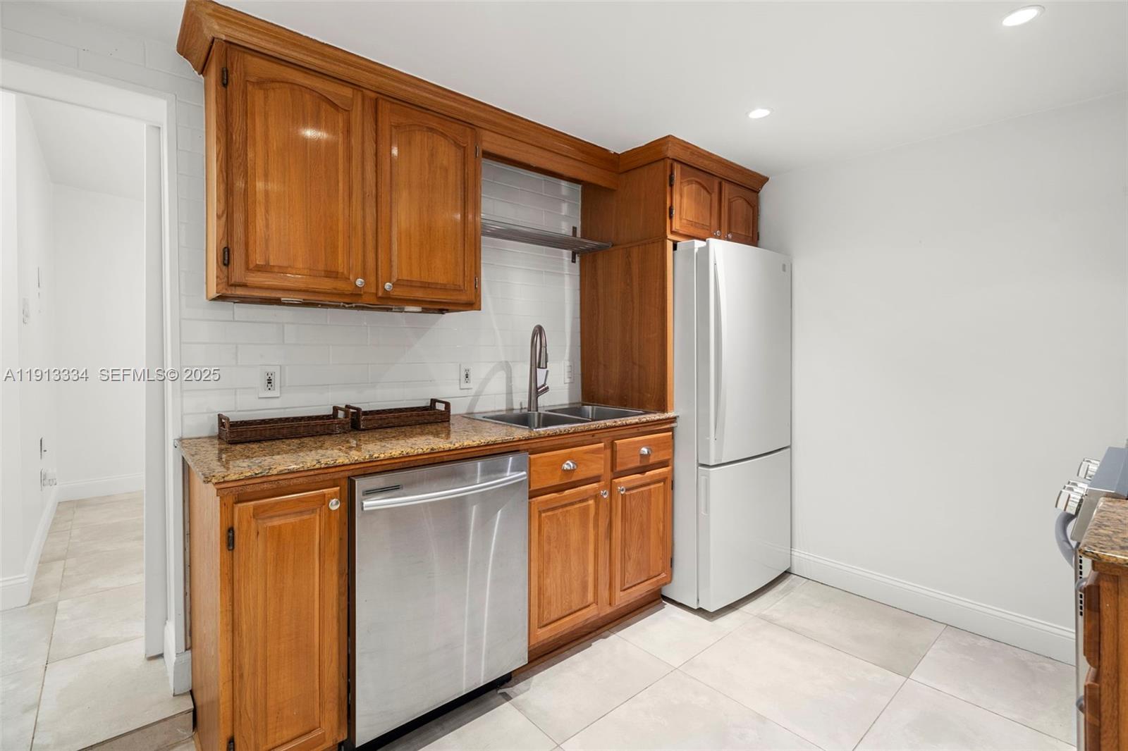 151 Northeast 43rd Street Miami, FL 33137 - Photo 49 of 51 a kitchen with stainless steel appliances granite countertop a refrigerator and a stove top oven