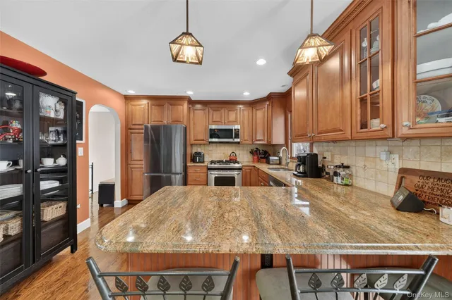 a kitchen with stainless steel appliances granite countertop a stove refrigerator sink and cabinets