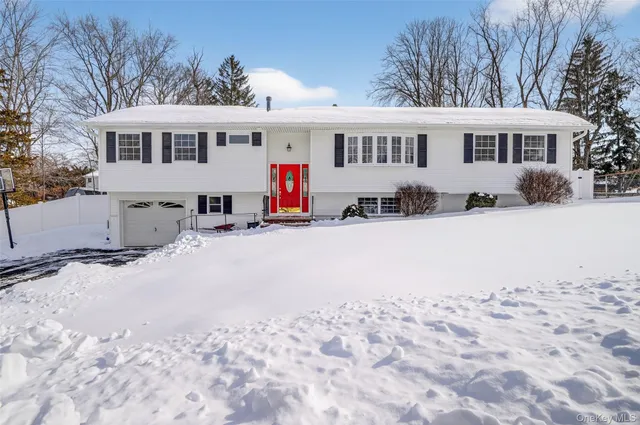 a view of a white house with snow on the road