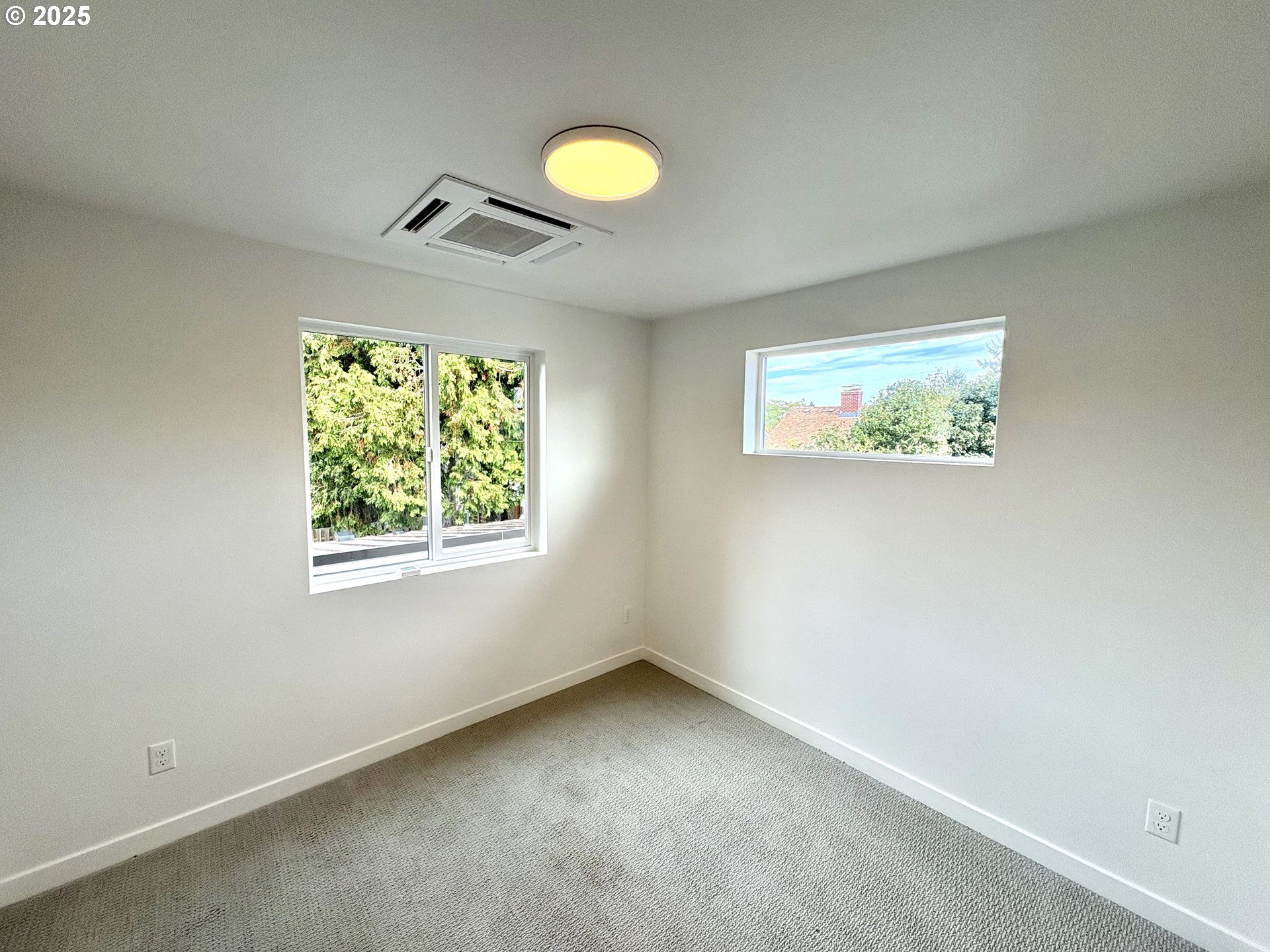 6 Northeast 74th Avenue, Unit C Portland, OR 97213 - Photo 6 of 9 an empty room with windows and fan