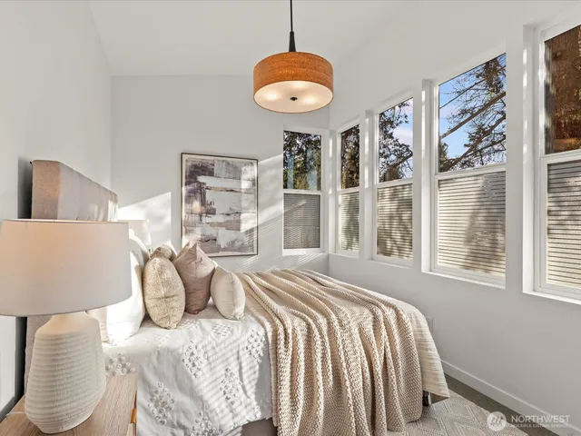 a bed sitting in a bedroom next to a window