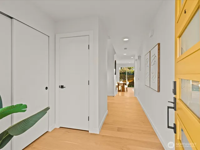 a view of a hallway with wooden floor and staircase