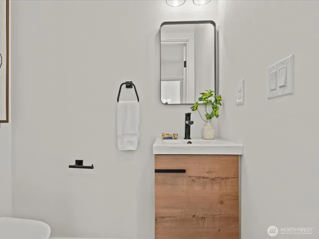 a bathroom with a sink a toilet and mirror