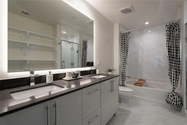 a bathroom with a granite countertop sink a large mirror and a bathtub
