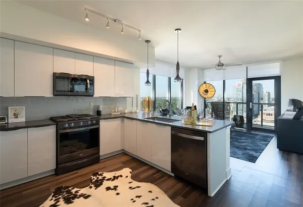 a kitchen with a sink stove and wooden floor