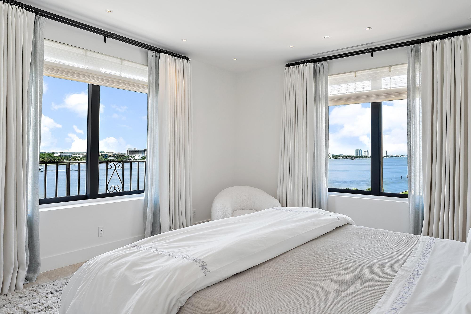 150 Bradley Place, Unit 712 Palm Beach, FL 33480 - Photo 11 of 44 a bedroom with a large bed and glass window
