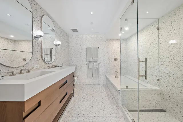 a bathroom with a double vanity sink mirror and shower