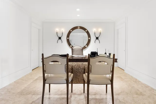 a living room with couches and kitchen view with wooden floor