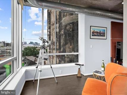 a living room with furniture kitchen view and a large window