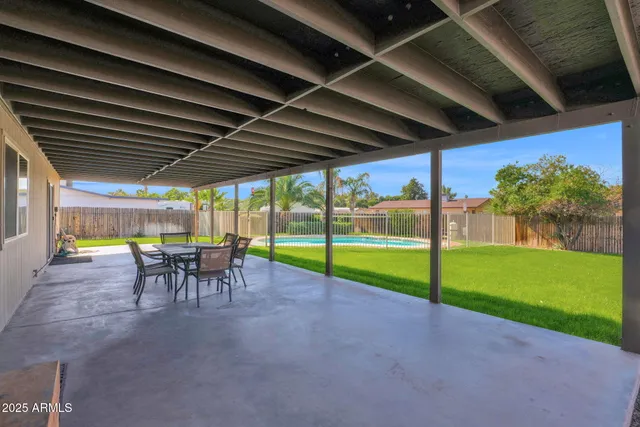 a view of a house with backyard and a tree