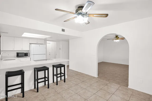 a kitchen with a white cabinets and chandelier