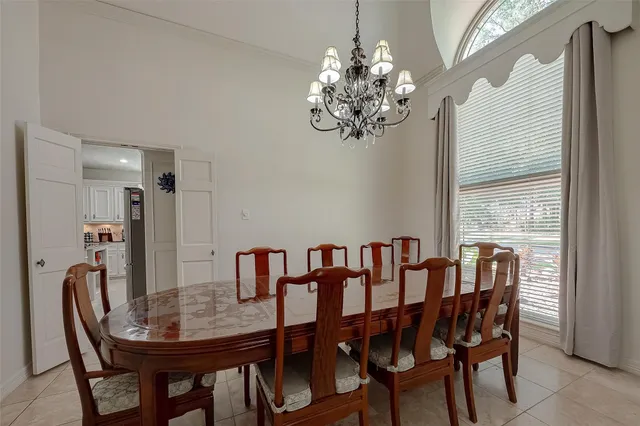 a view of a dining room with furniture a chandelier and window