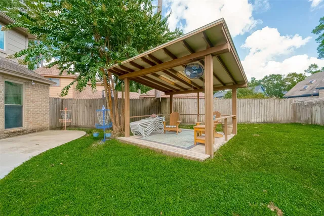 a view of a backyard with table and chairs and a barbeque