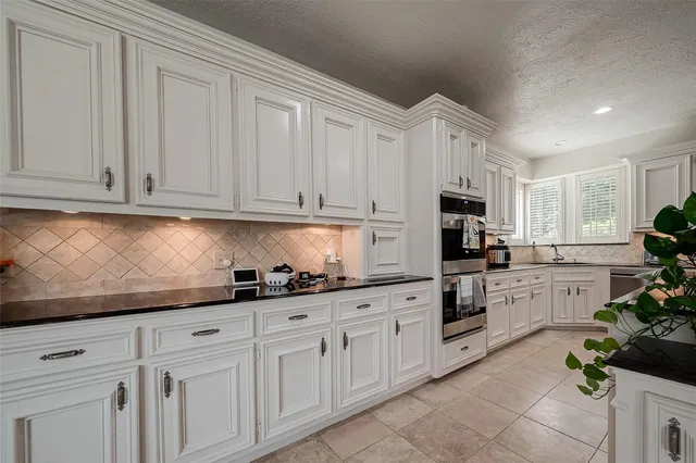 a kitchen with white cabinets and white appliances