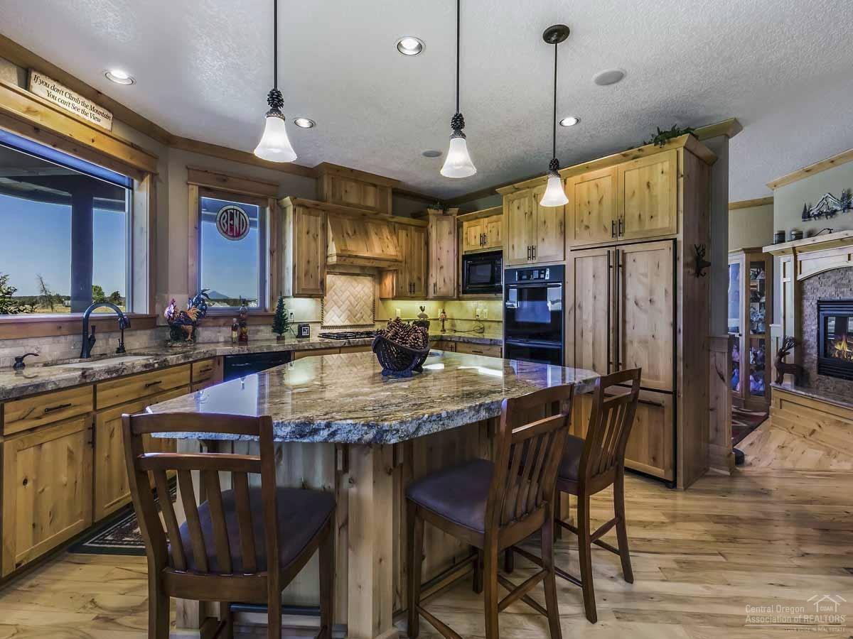 20200 Marsh Road Bend, OR 97703 - Photo 8 of 25 a kitchen with stainless steel appliances granite countertop a stove a refrigerator a kitchen island a table and chairs