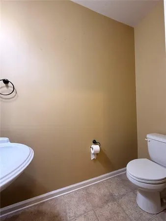 a view of an empty room with wooden floor and a ceiling fan