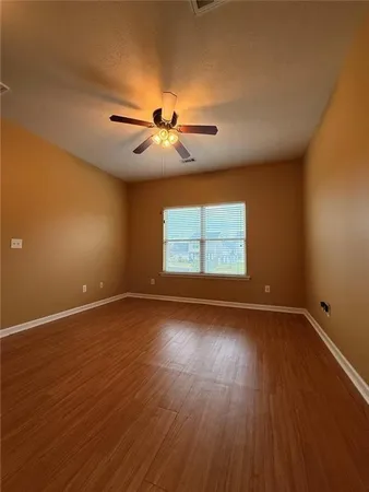 an empty room with windows and fan