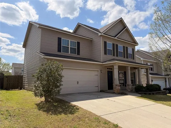 a view of an empty room with wooden floor and stairs