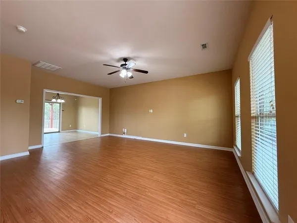 wooden floor in an empty room with a window