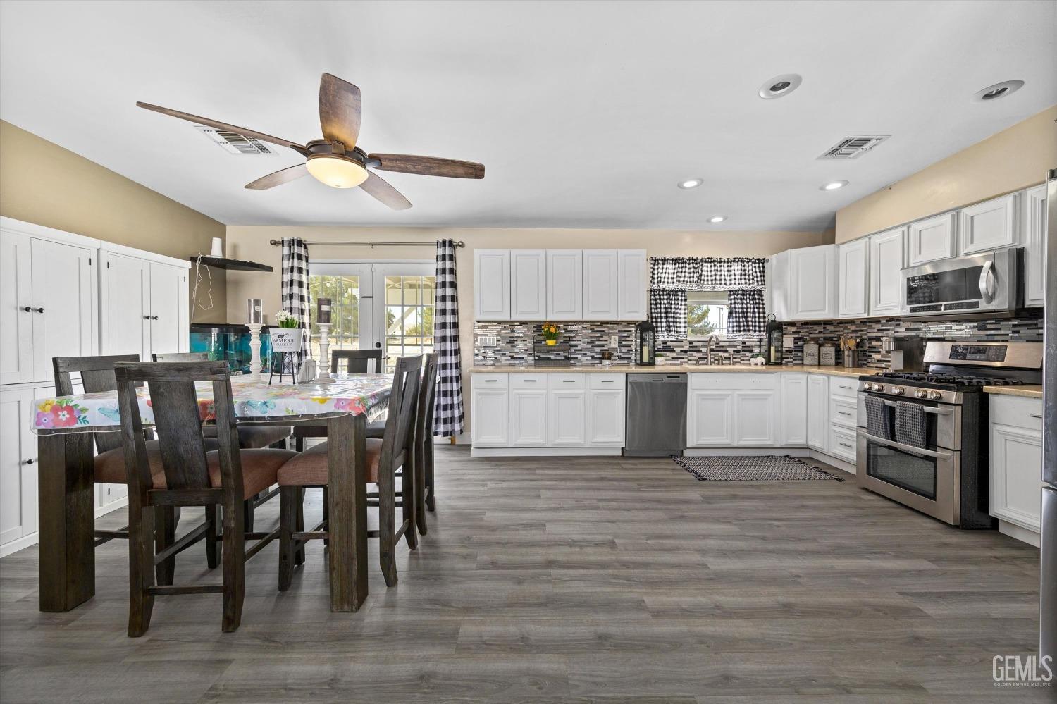 Undisclosed Address Maricopa, CA 93252 - Photo 23 of 47 a kitchen with stainless steel appliances kitchen island granite countertop a table chairs and a refrigerator