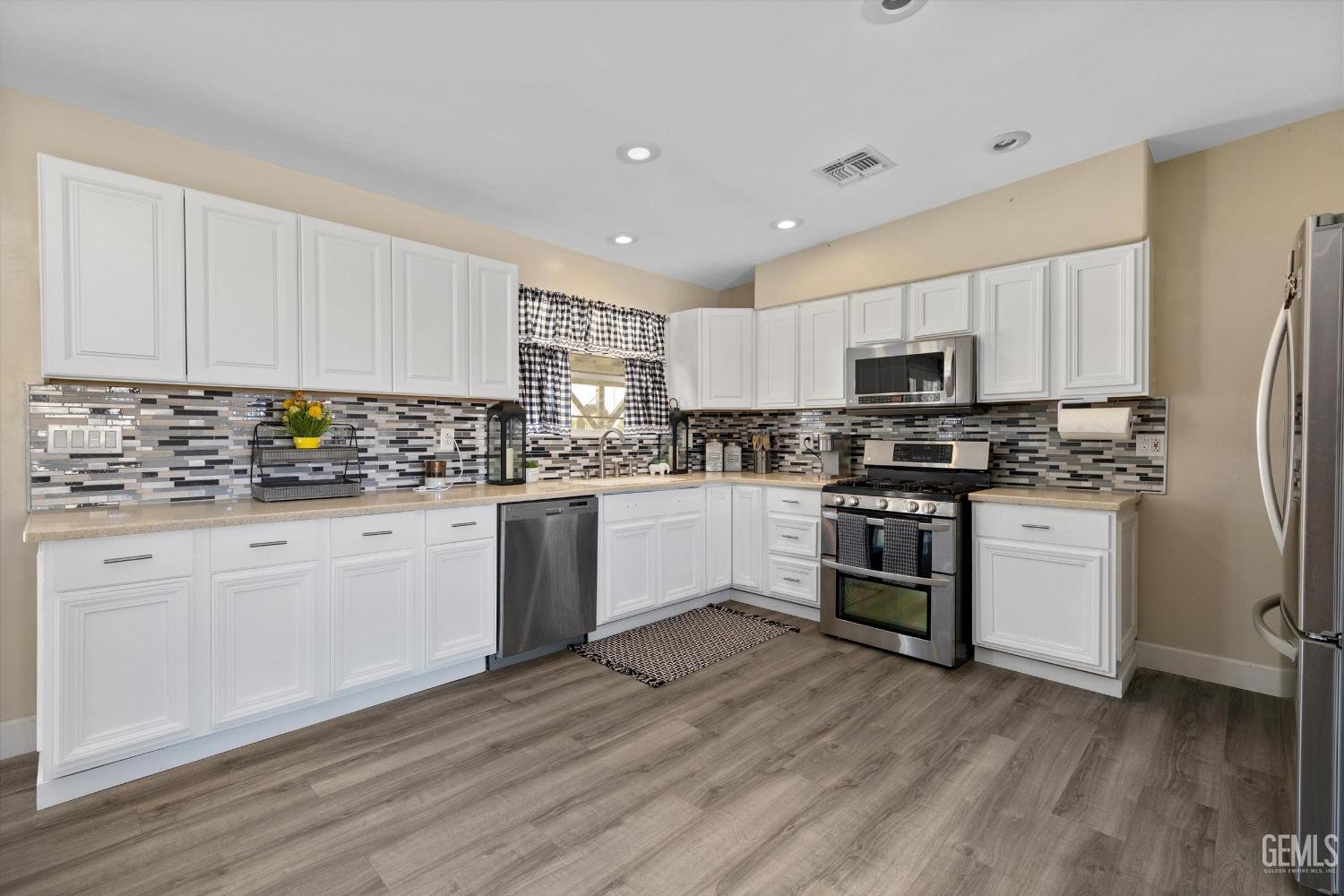 Undisclosed Address Maricopa, CA 93252 - Photo 26 of 47 a kitchen with granite countertop white cabinets and stainless steel appliances