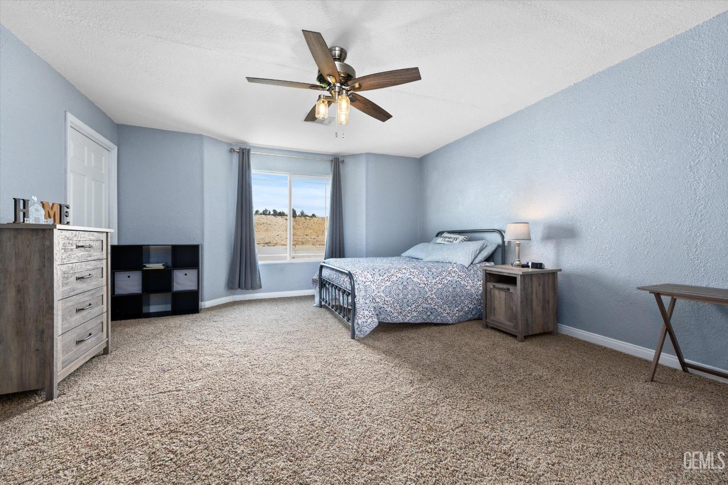 Undisclosed Address Maricopa, CA 93252 - Photo 31 of 47 a bedroom with a bed and a ceiling fan