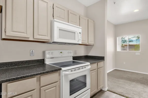 a kitchen with granite countertop white cabinets and white appliances