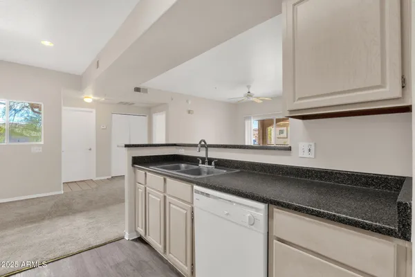 a kitchen with granite countertop white cabinets and a sink