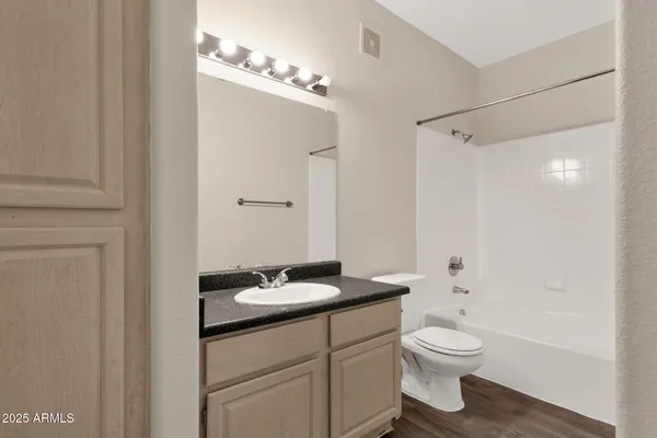 a bathroom with a granite countertop sink toilet a mirror and shower