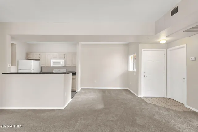 a kitchen with stainless steel appliances a refrigerator and white cabinets
