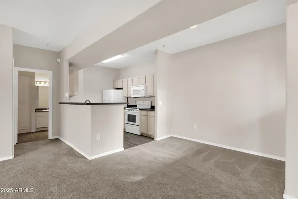 a kitchen with stainless steel appliances a refrigerator and white cabinets