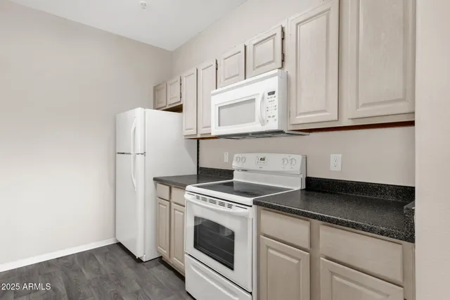 a kitchen with granite countertop white cabinets and white appliances
