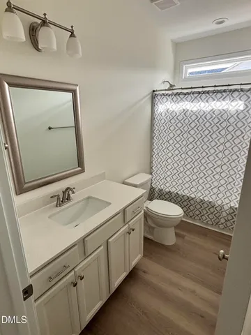 a bathroom with a granite countertop toilet sink and mirror