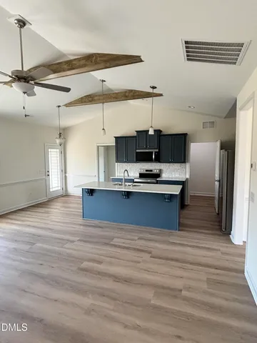 a kitchen with kitchen island stainless steel appliances a sink and refrigerator