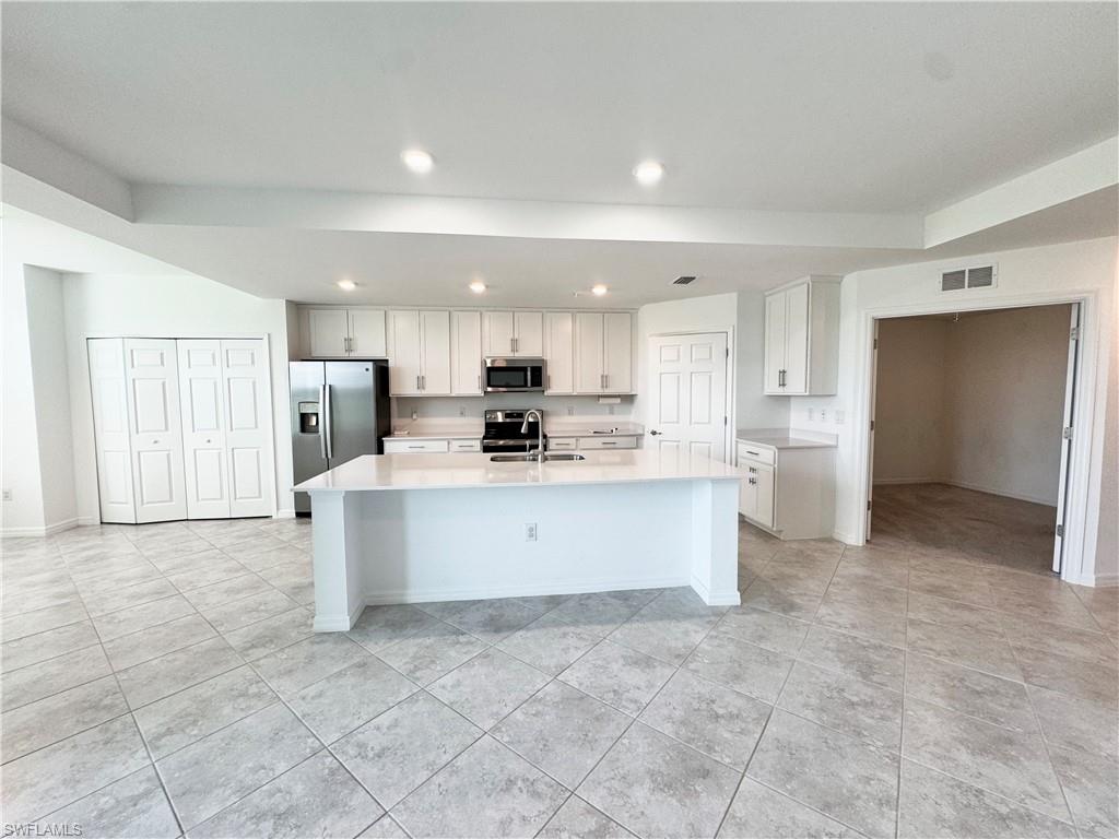 15970 Grassland Lane, Unit 2813 Babcock Ranch, FL 33982 - Photo 11 of 39 Kitchen with white cabinetry, sink, an island with sink, and stainless steel appliances